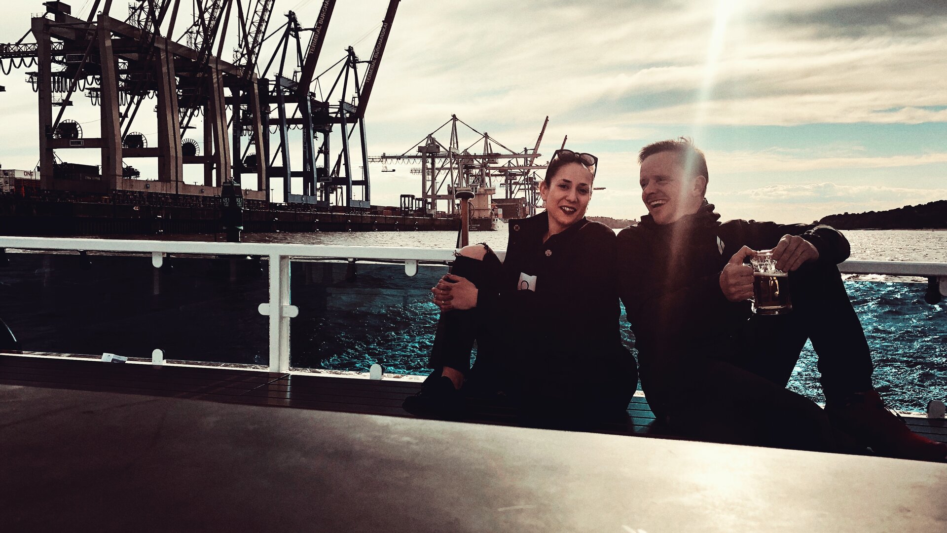 sags-Teammitglieder auf einem Schiff vor Hafenkulisse.