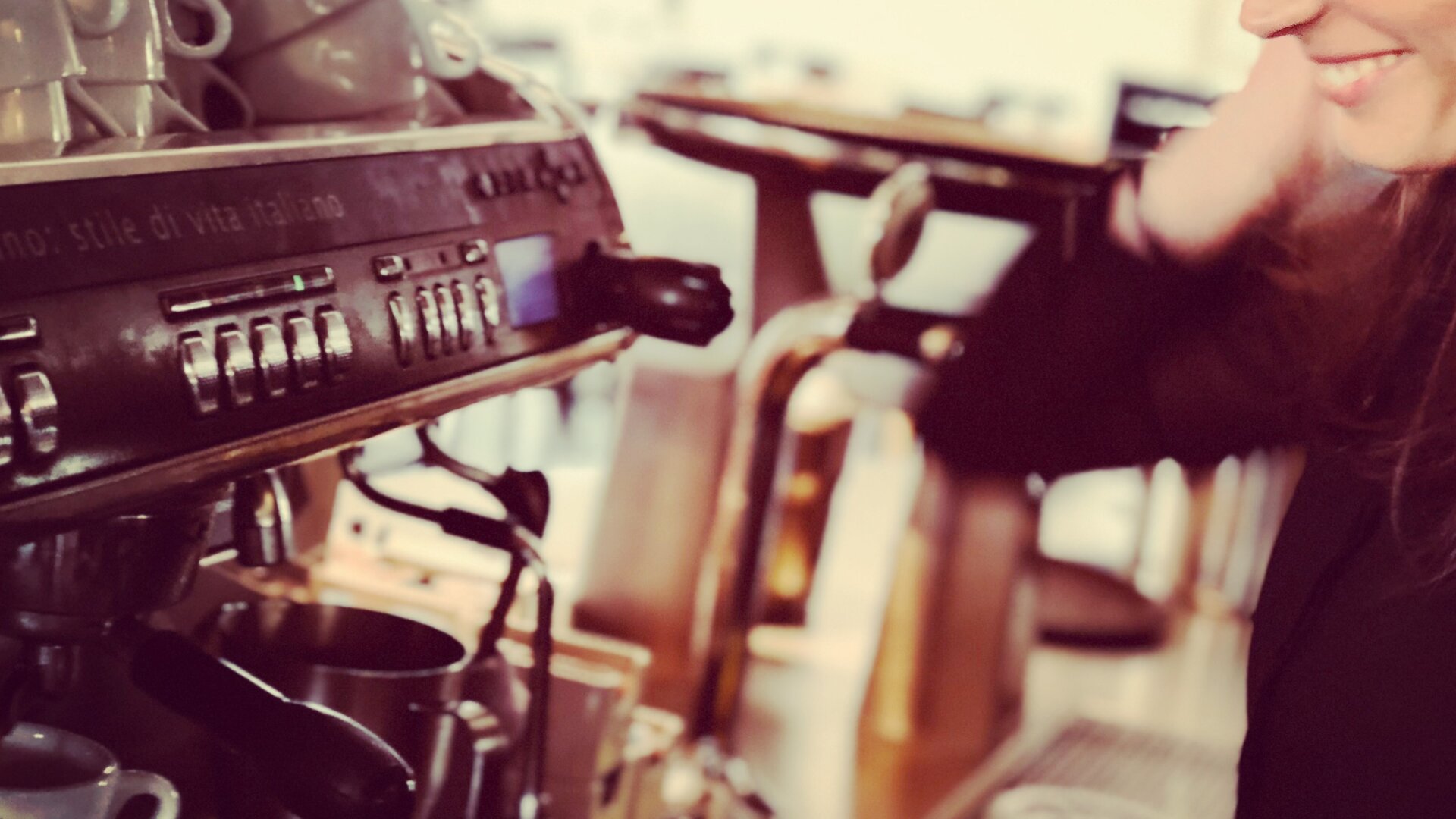 Mitarbeiterin von sags an einer Kaffeemaschine.