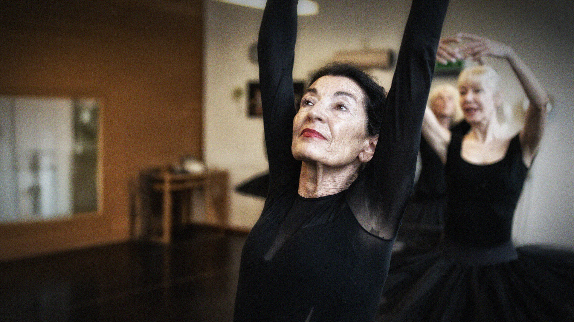 Zwei Tänzerinnen in schwarzem Tutu tanzen in einem Ballettstudio.