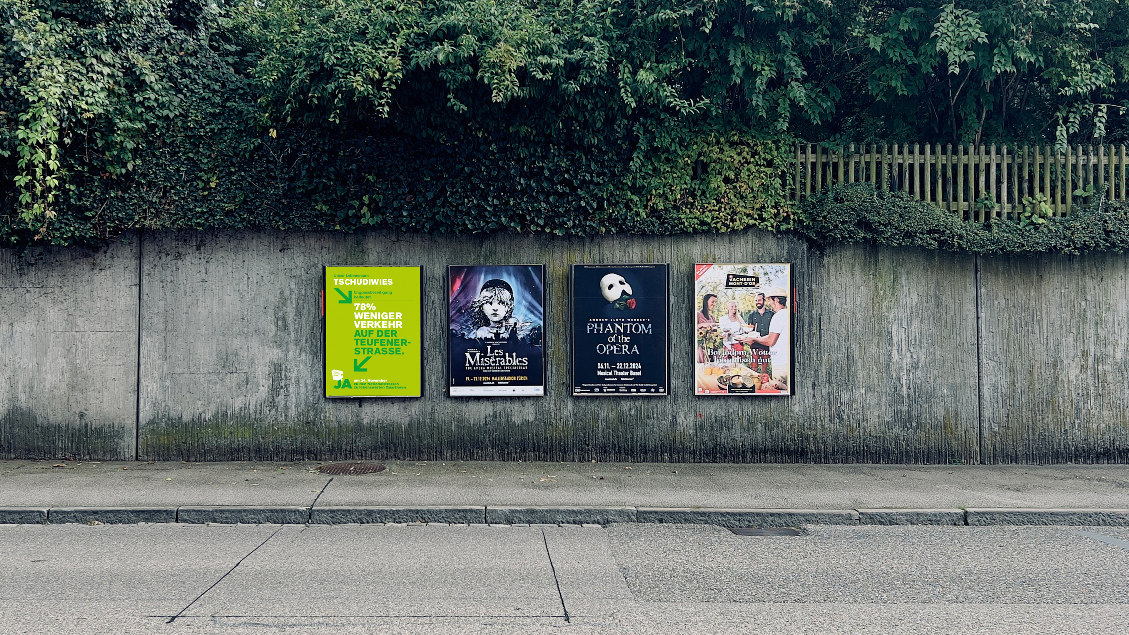 Vier Plakate an einer Strassenwand, links ein grünes Kampagnenplakat Unser Lebensraum, daneben Theater- und Eventplakate.