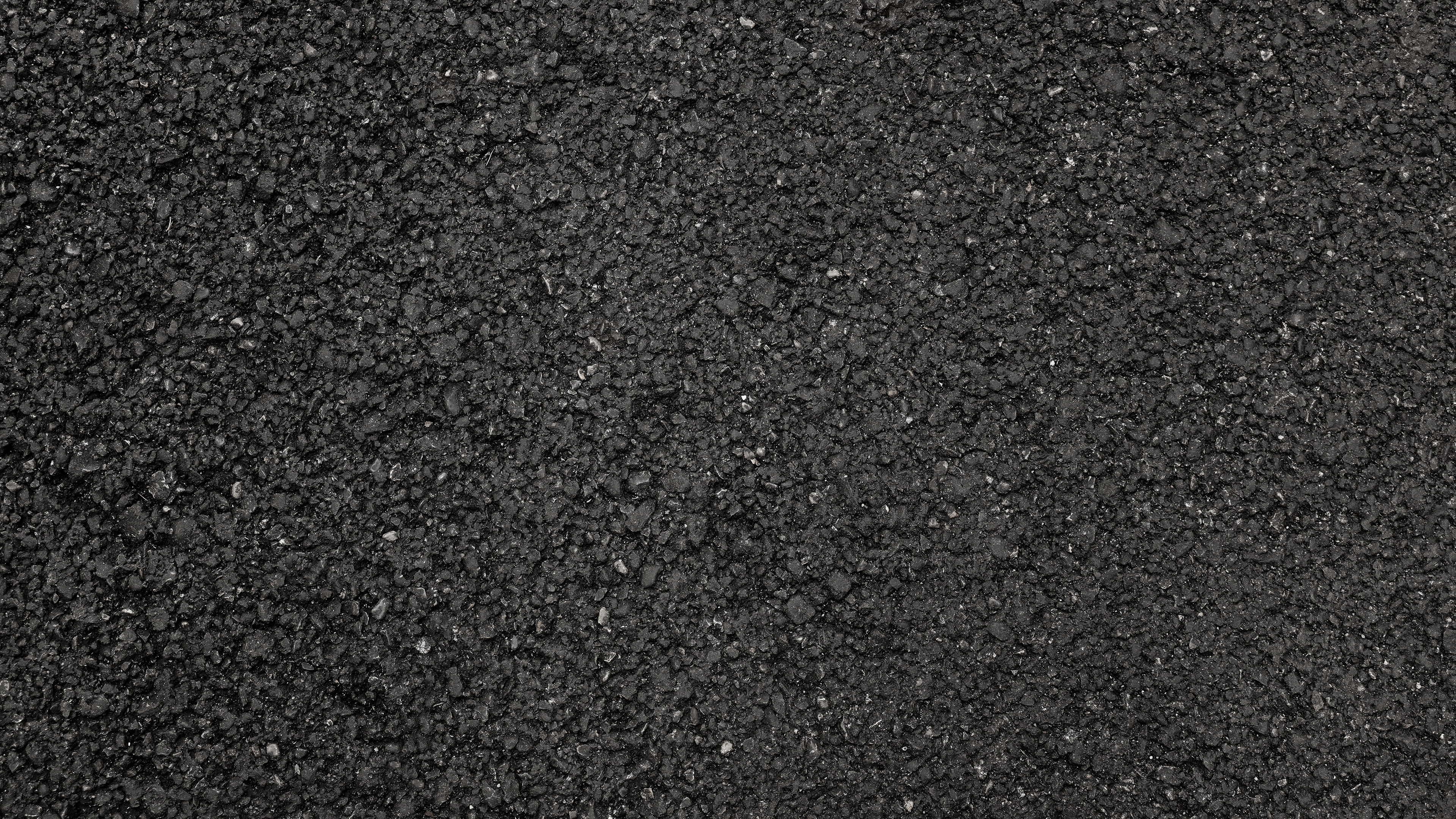 Strukturierte schwarze Asphaltfläche in Detailansicht.