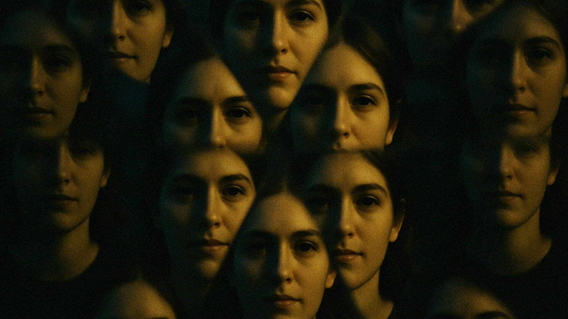 Mehrfachbelichtung von Gesichtern einer Frau in dunkler Umgebung. Verspiegelt wie durch ein Prisma dargestellt.