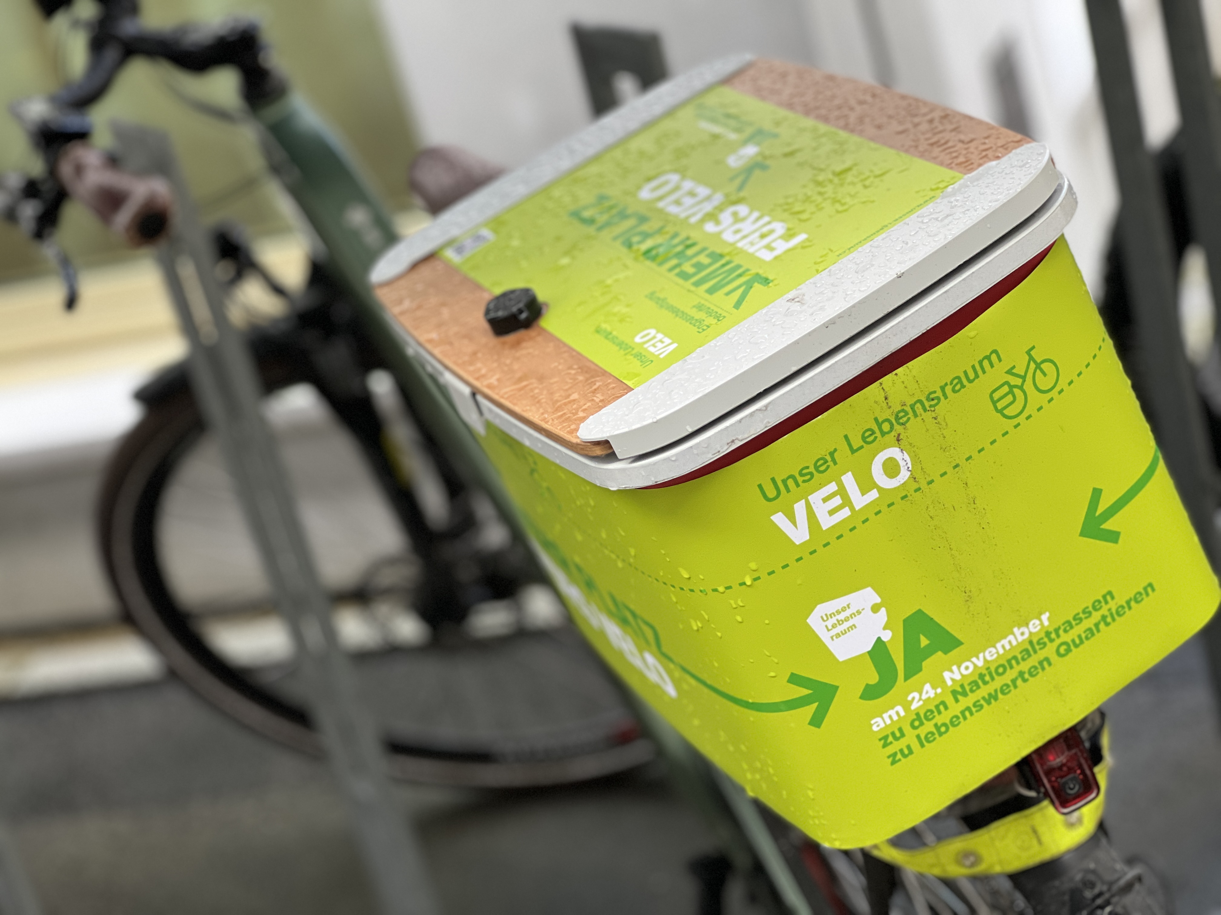 Grünes Werbeschild der STEP-Kampagne auf einem Fahrradkorb im Stadtgebiet.