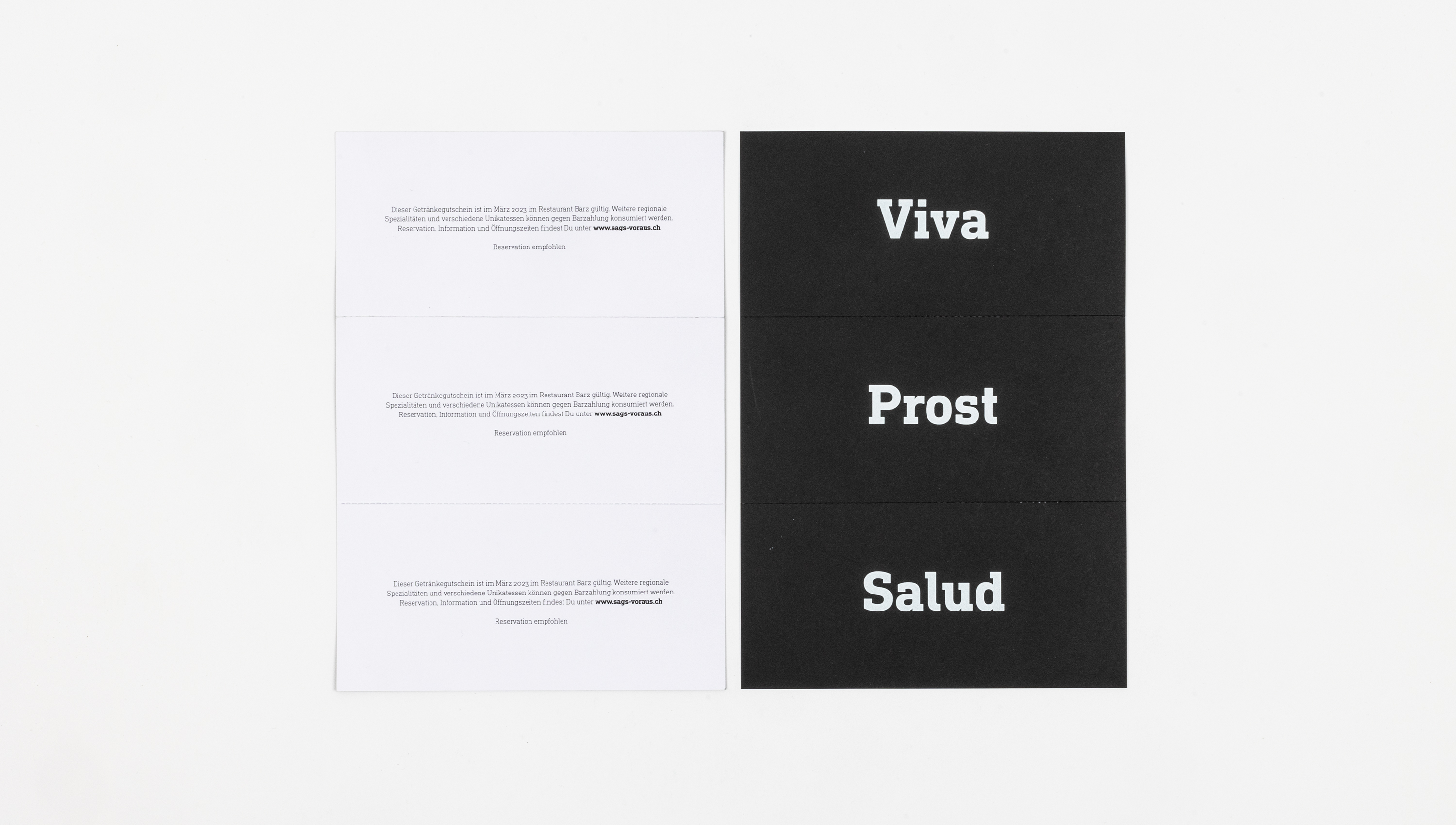 Zwei Karten mit Texten, eine davon mit den Worten „Viva“, „Prost“ und „Salud“.